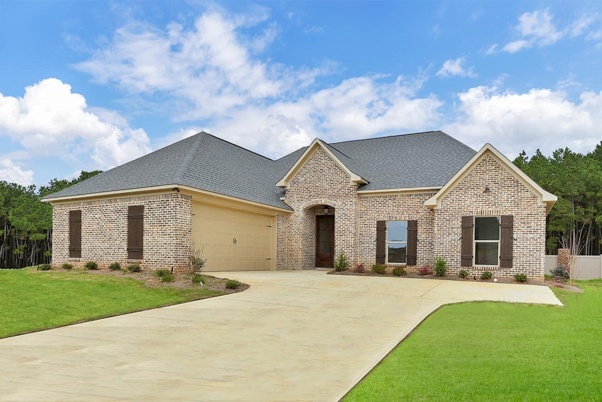 House plan exterior. Single-story home with brick facade, gable roof, and attached garage. Includes shutters and a covered entry.