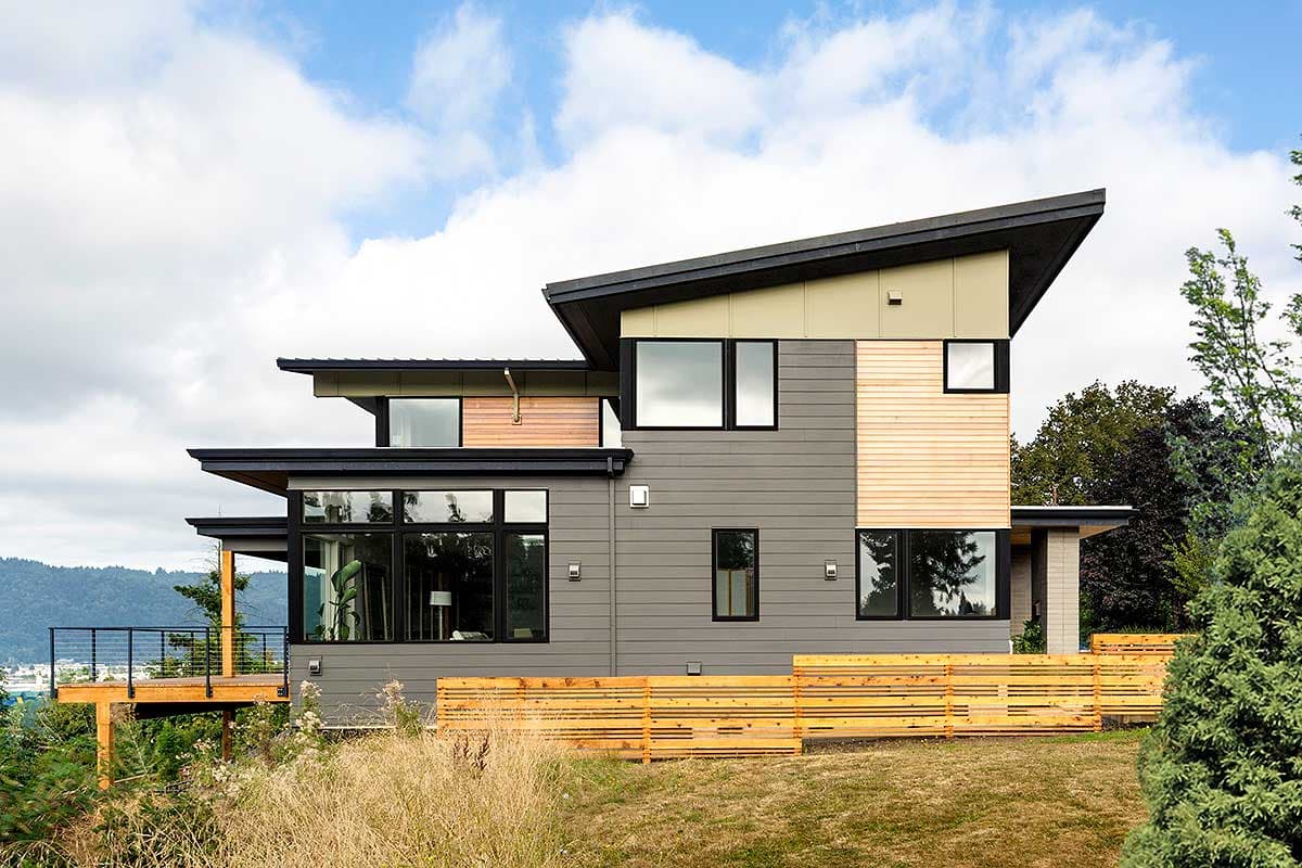 Modern house plan exterior with multiple levels, angled rooflines, large windows, and wood and gray siding.