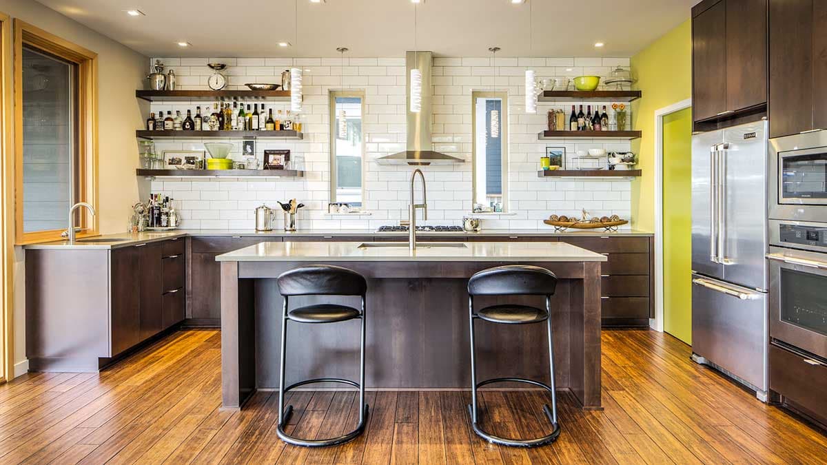 Modern kitchen with island, subway tile backsplash, stainless steel appliances, and dark wood cabinetry.