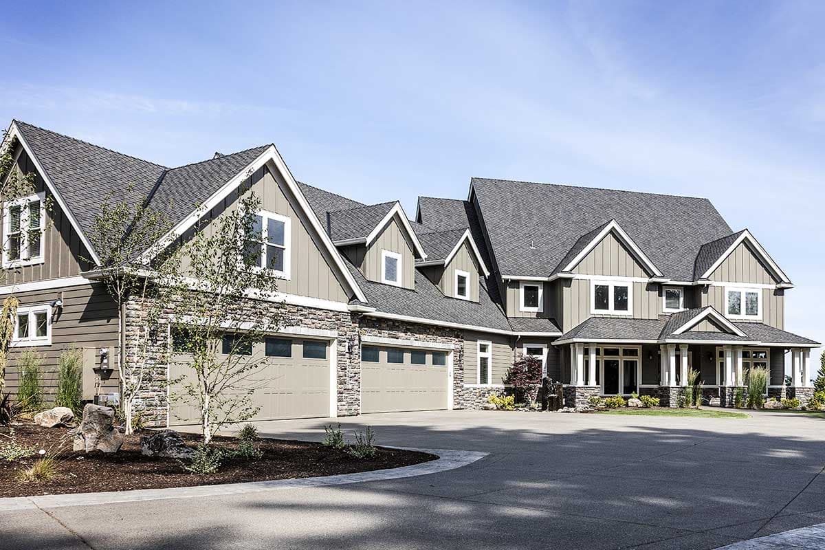 Modern Farmhouse house plan exterior with stone accents, multiple gables, dormers, and a four-car garage.