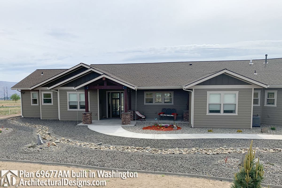 Ranch house plan exterior with covered entry porch, dual gables, and stone-clad support columns.