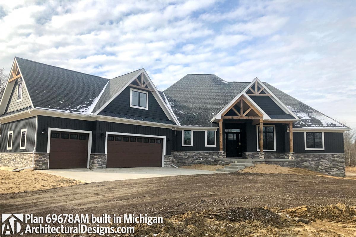 Modern Farmhouse style house plan exterior with a side-facing three-car garage, gabled dormers, and timber accents.