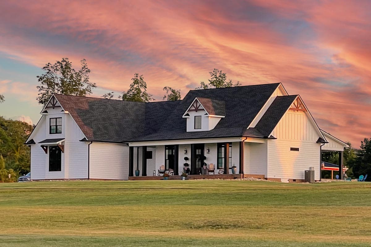 House plan exterior. Two-story Modern Farmhouse with gables, dormers, and a covered porch. White siding with dark roof and trim.