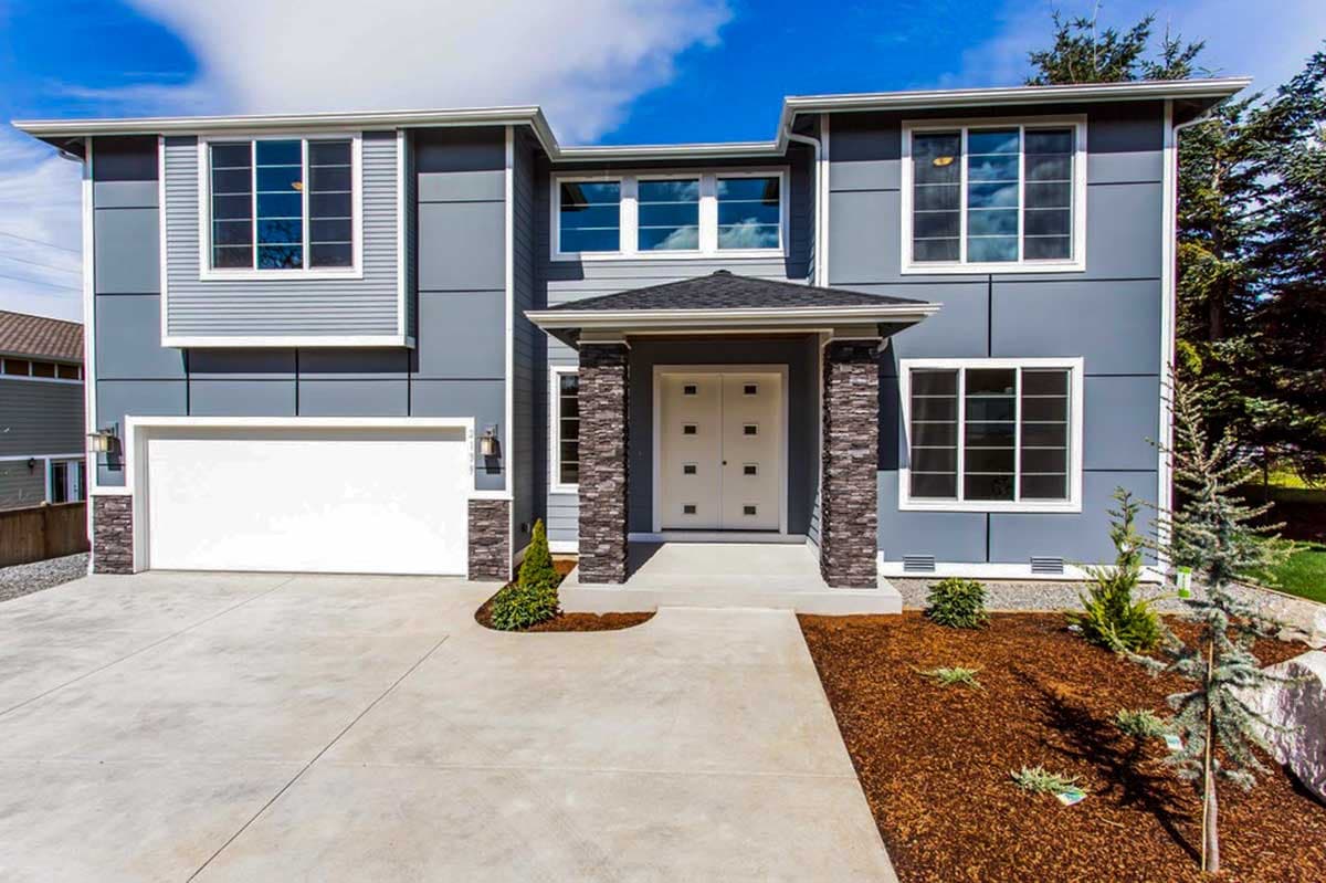 House plan exterior with two stories and modern facade. Features include a front entry portico with stone columns and a two-car garage.