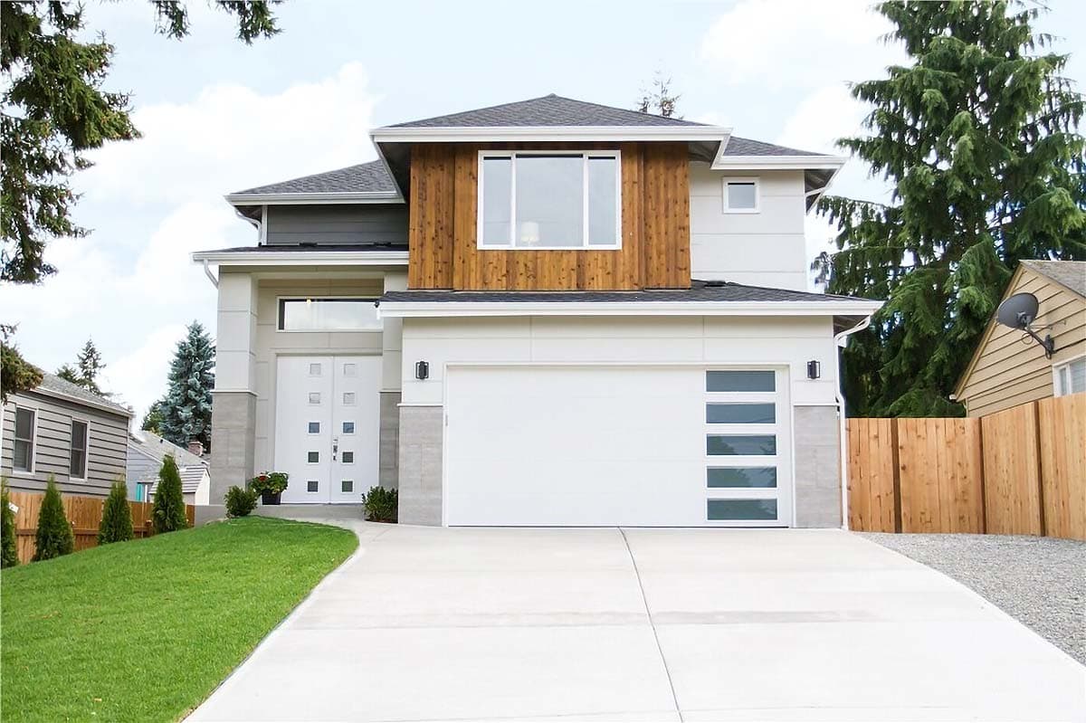 House plan exterior. Two-story modern home with wood accents and a two-car garage. Features include a flat roof and large windows.