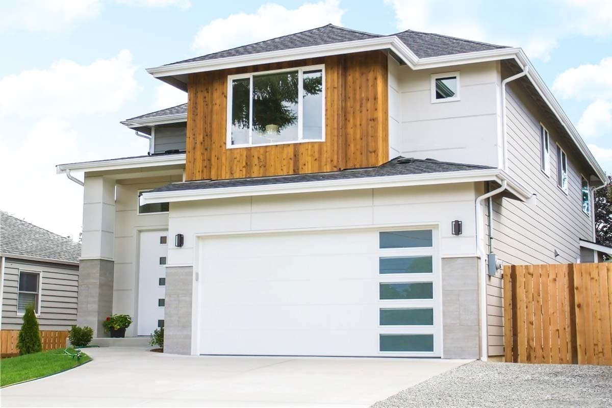 Modern two-story house plan exterior with wood siding accent, large windows, and multi-panel garage door.