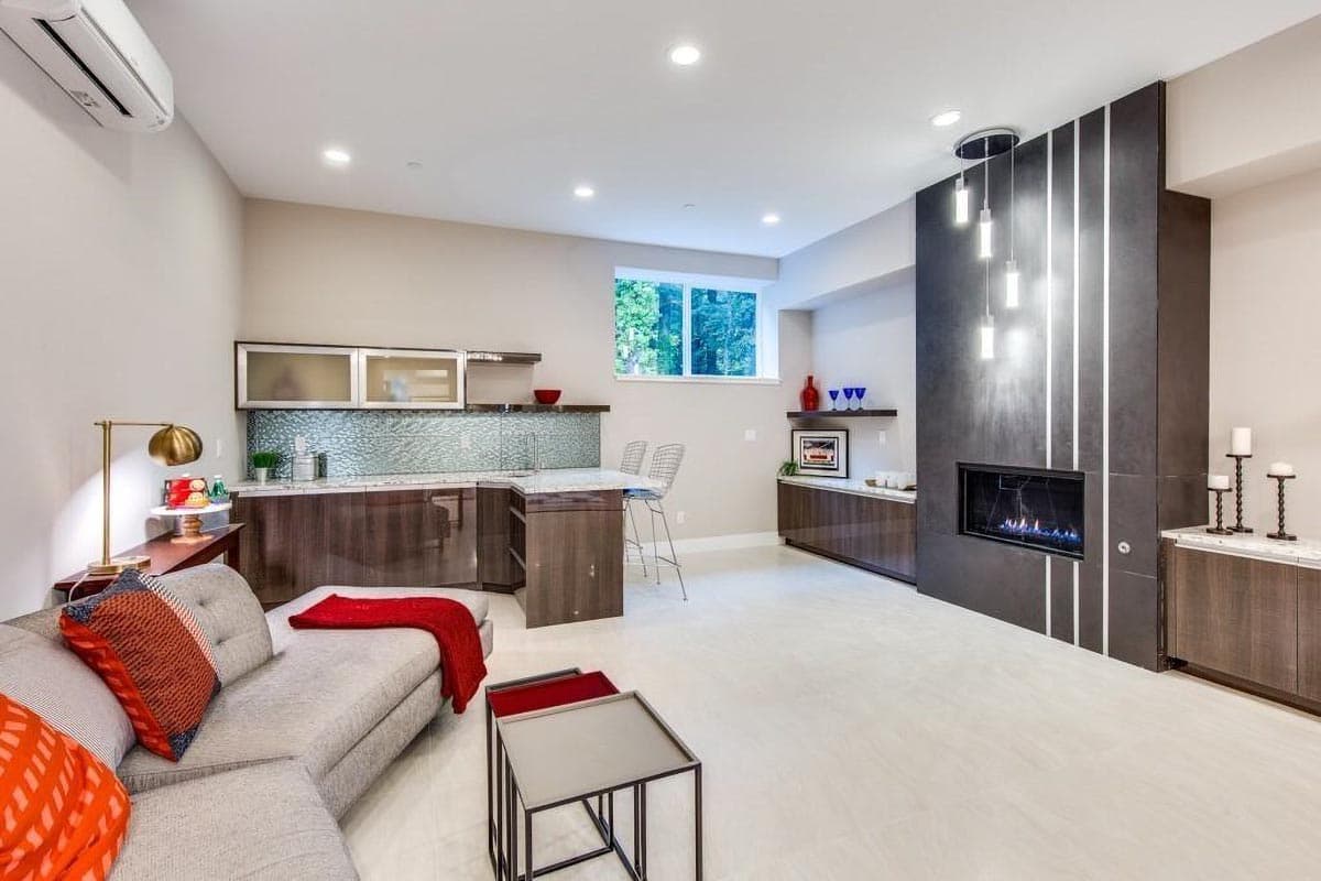 Modern living room with fireplace, wet bar, sectional sofa, and contemporary lighting. Open layout.