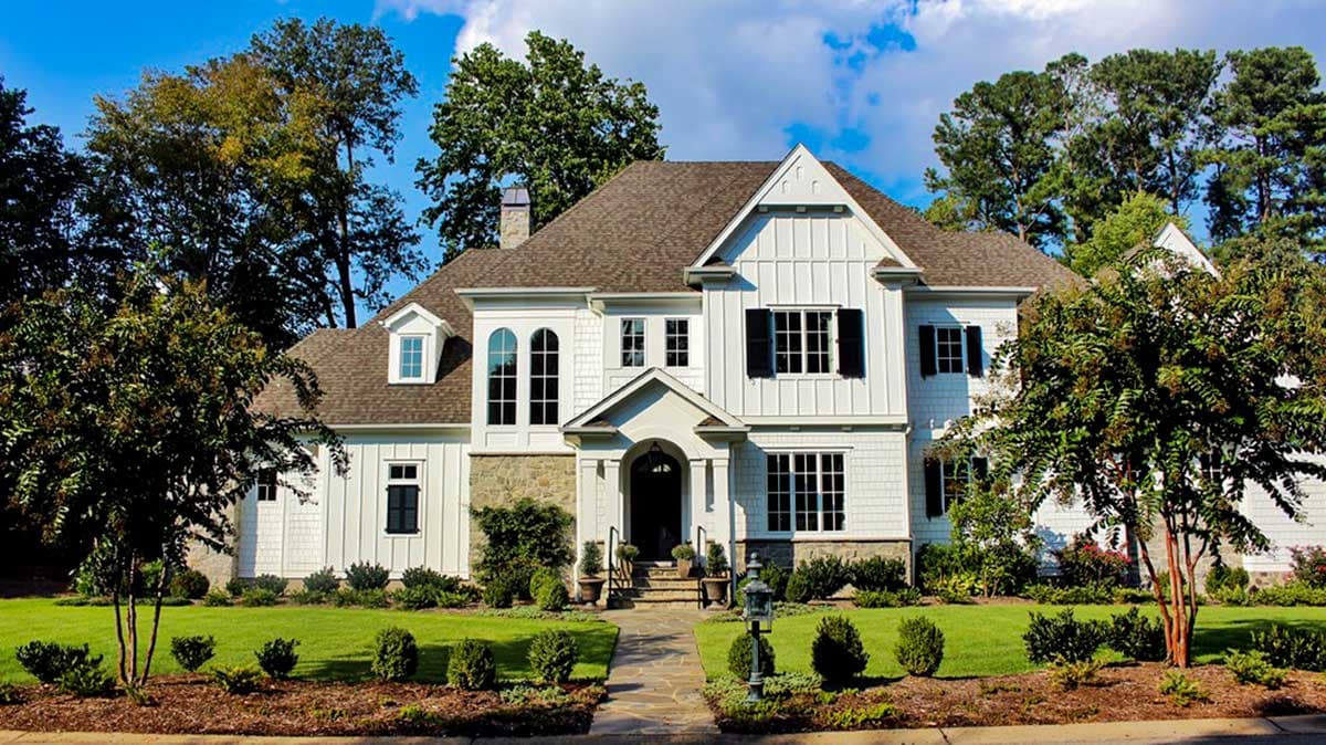 House plan exterior: two-story Modern Farmhouse with stone and board-and-batten siding, arched windows, and covered entry.