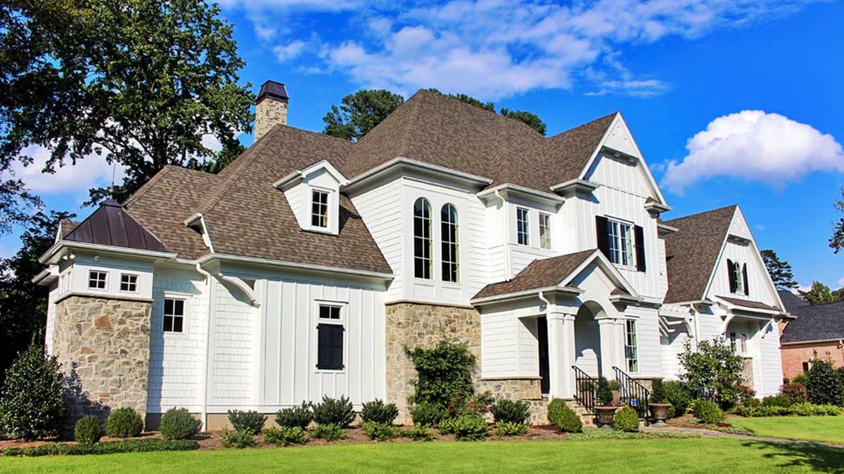 House plan exterior: modern farmhouse style, two stories, stone base, board and batten siding, gables, and dormers.