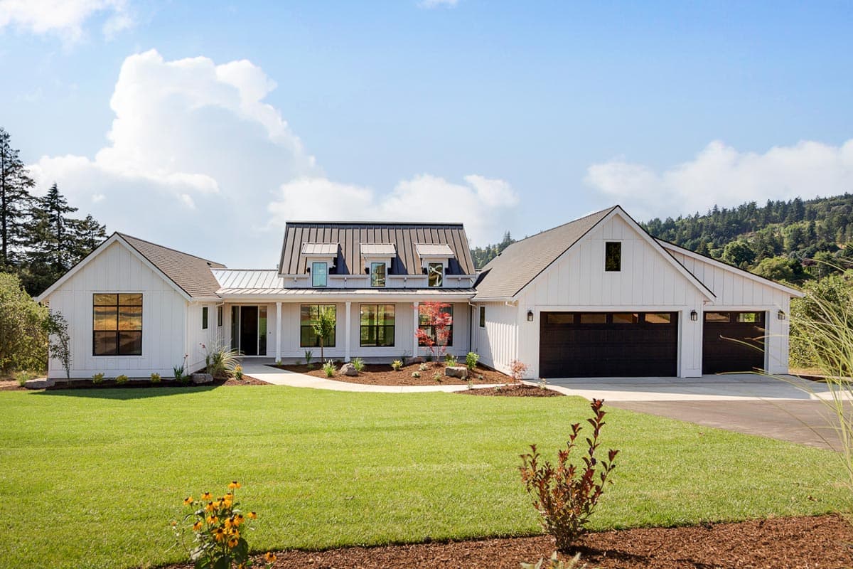 House plan exterior. Modern Farmhouse style, one-story. Features include a front porch, multiple gables, and a two-car garage.