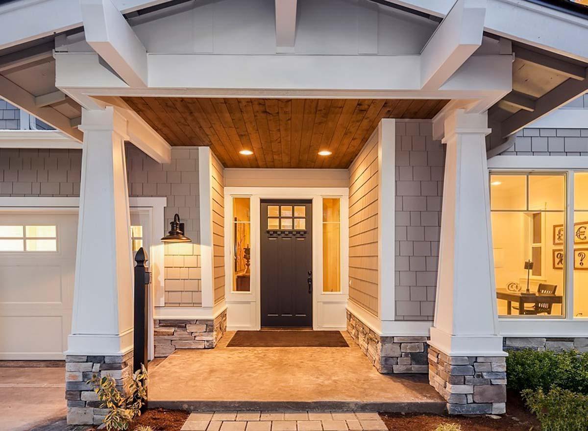 Craftsman style house plan exterior with a covered porch, stone accents, shingle siding, and exposed rafter tails.