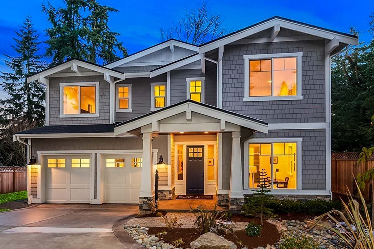House plan exterior with Craftsman style, two stories, front porch with columns, gables, and a two-car garage.