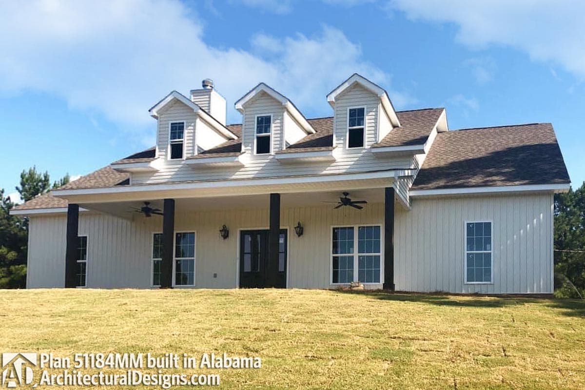 House plan exterior with front porch, dormers, and board and batten siding.