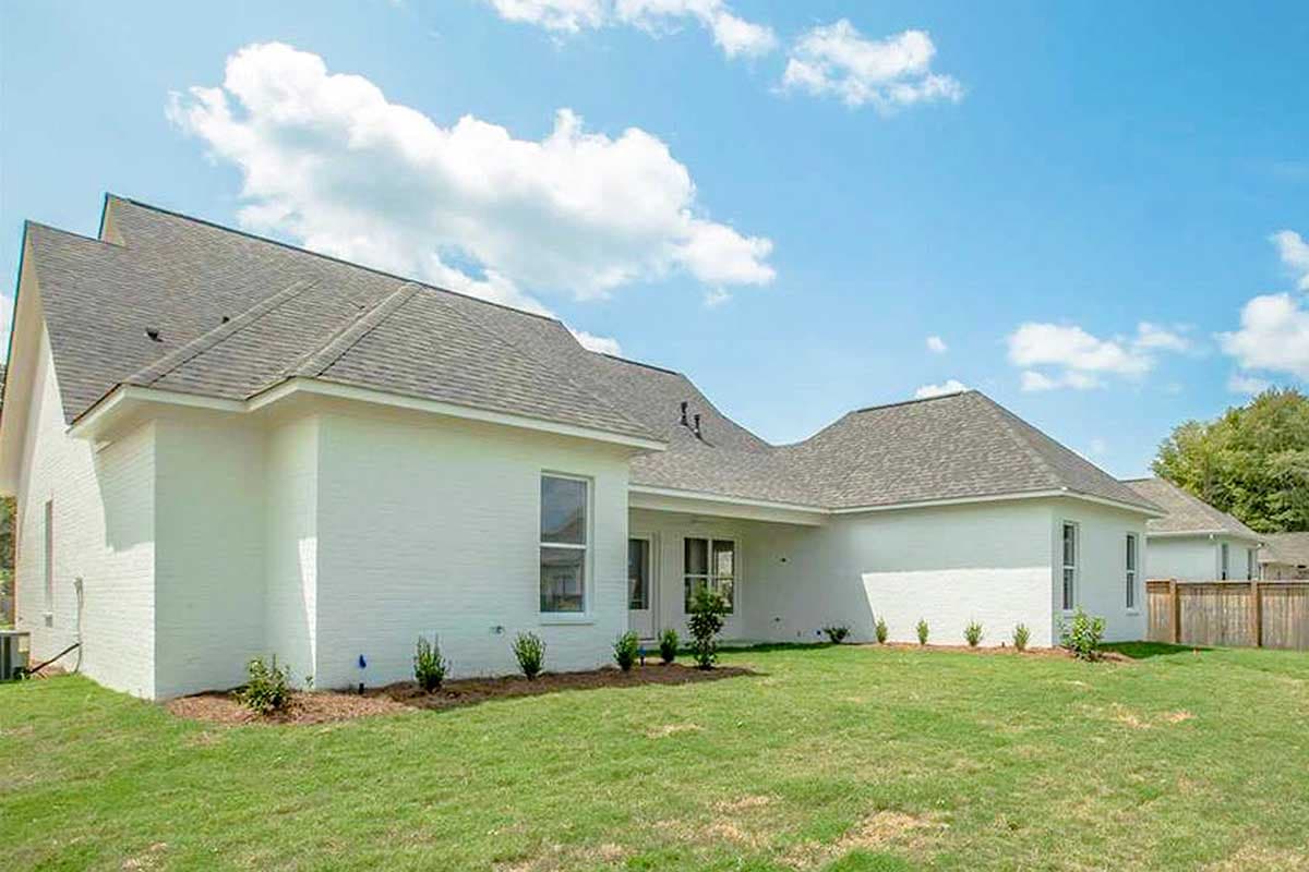 House plan exterior: one-story, white brick construction with a varied roofline and multiple gables.
