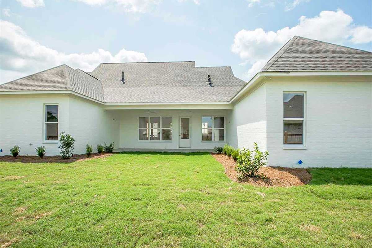 House plan exterior with white brick, hipped roof, and covered patio with multiple windows.