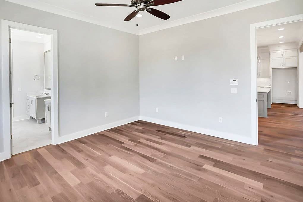 Interior view of bedroom with doorway to bathroom and view into kitchen with island.