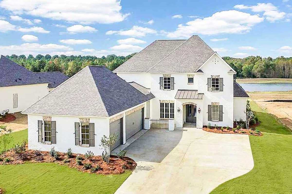 Two-story Modern Farmhouse exterior with attached garage, prominent gables, shutters, and covered entry.