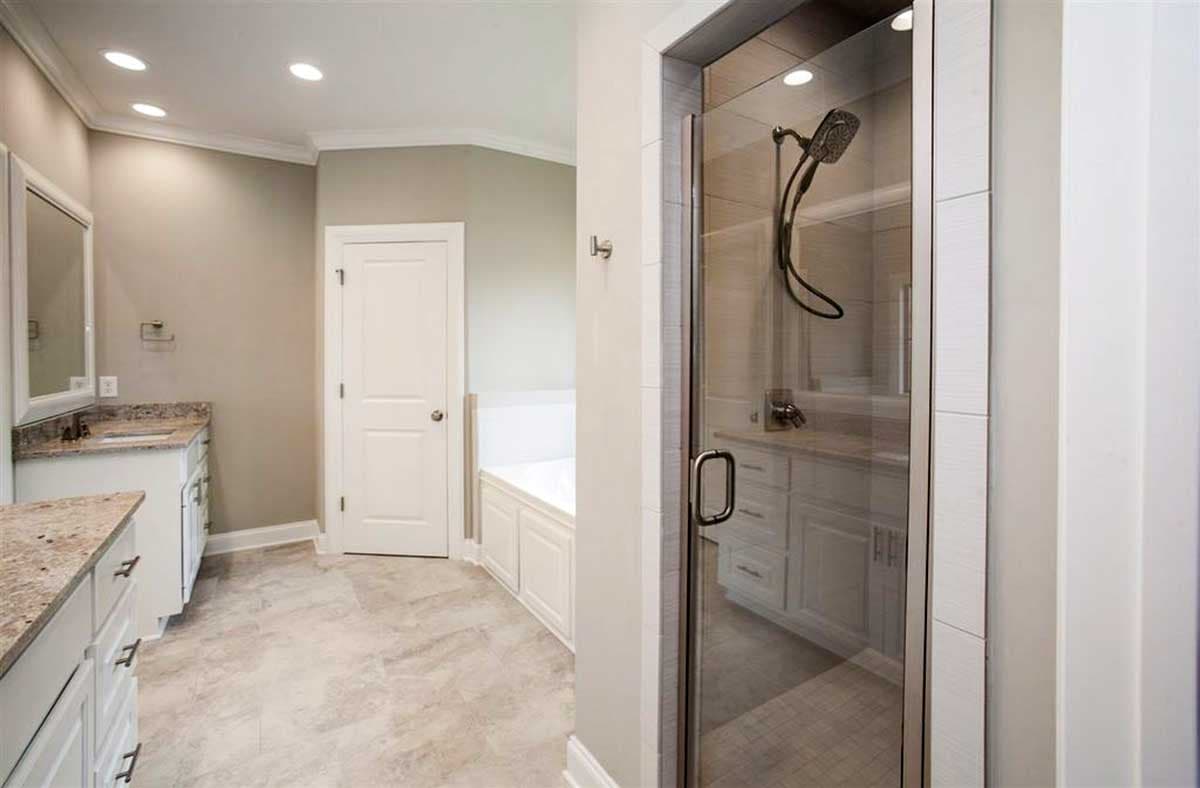 Bathroom with walk-in shower, vanity with dual sinks, and a built-in bathtub.