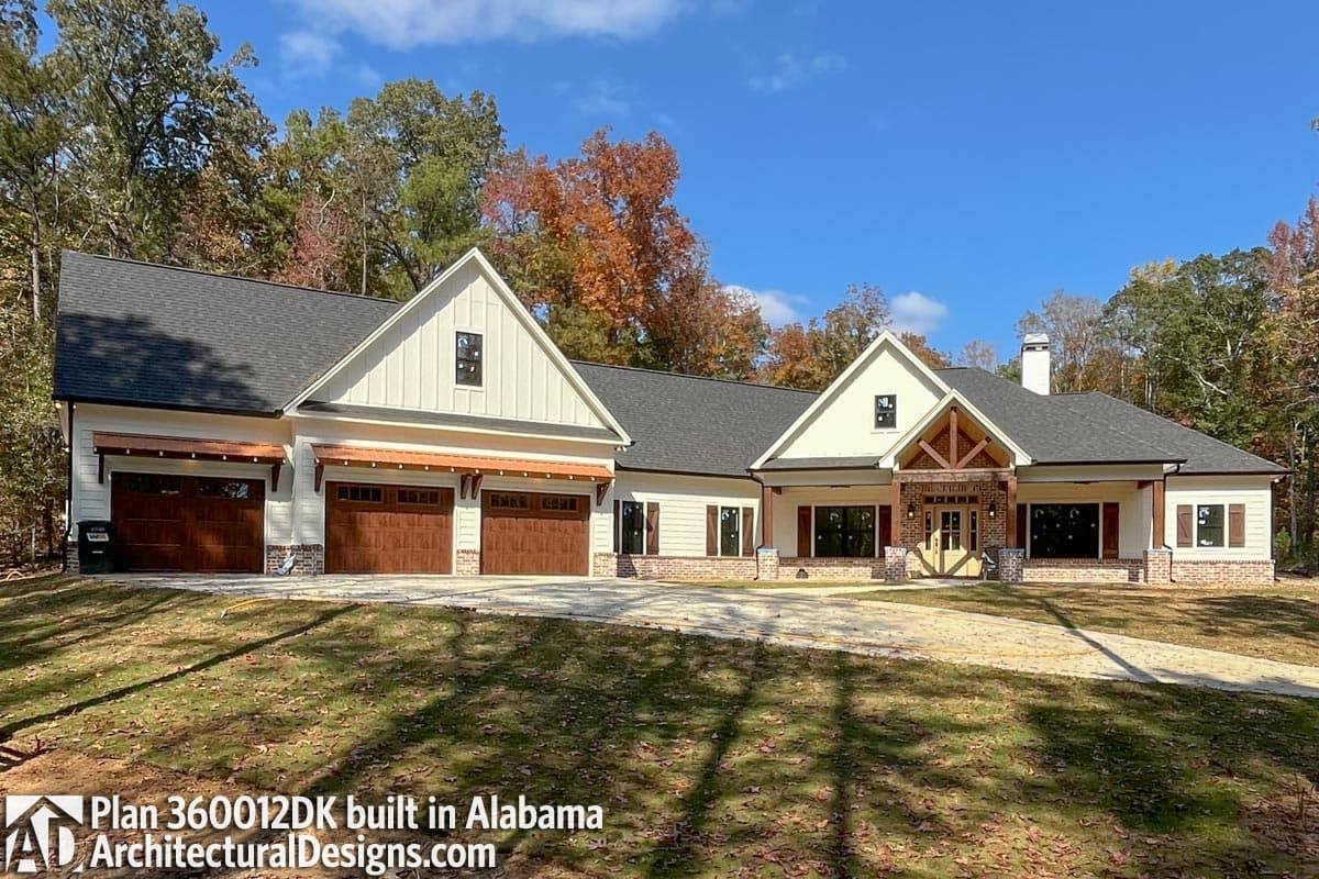 Modern Farmhouse style house plan exterior with a triple garage, gables, stone accents, and covered porches.