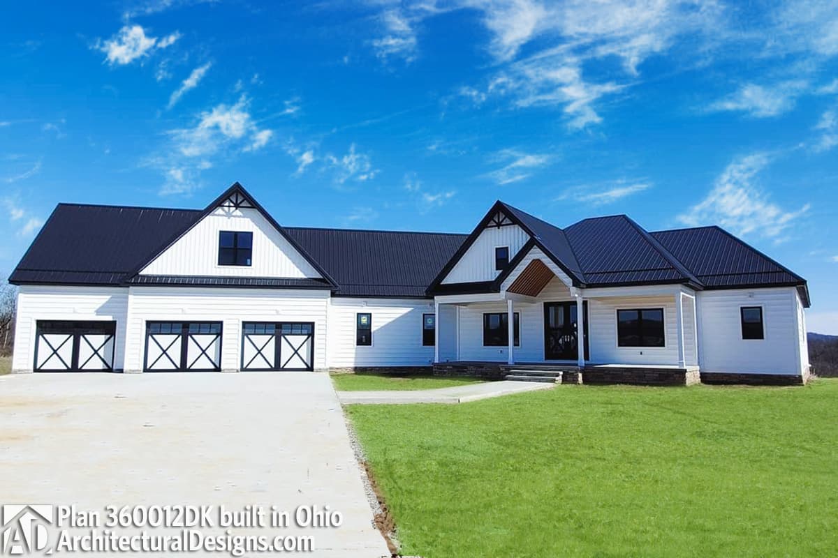 Modern Farmhouse house plan exterior with a white board-and-batten finish, black metal roof, and a three-car garage.