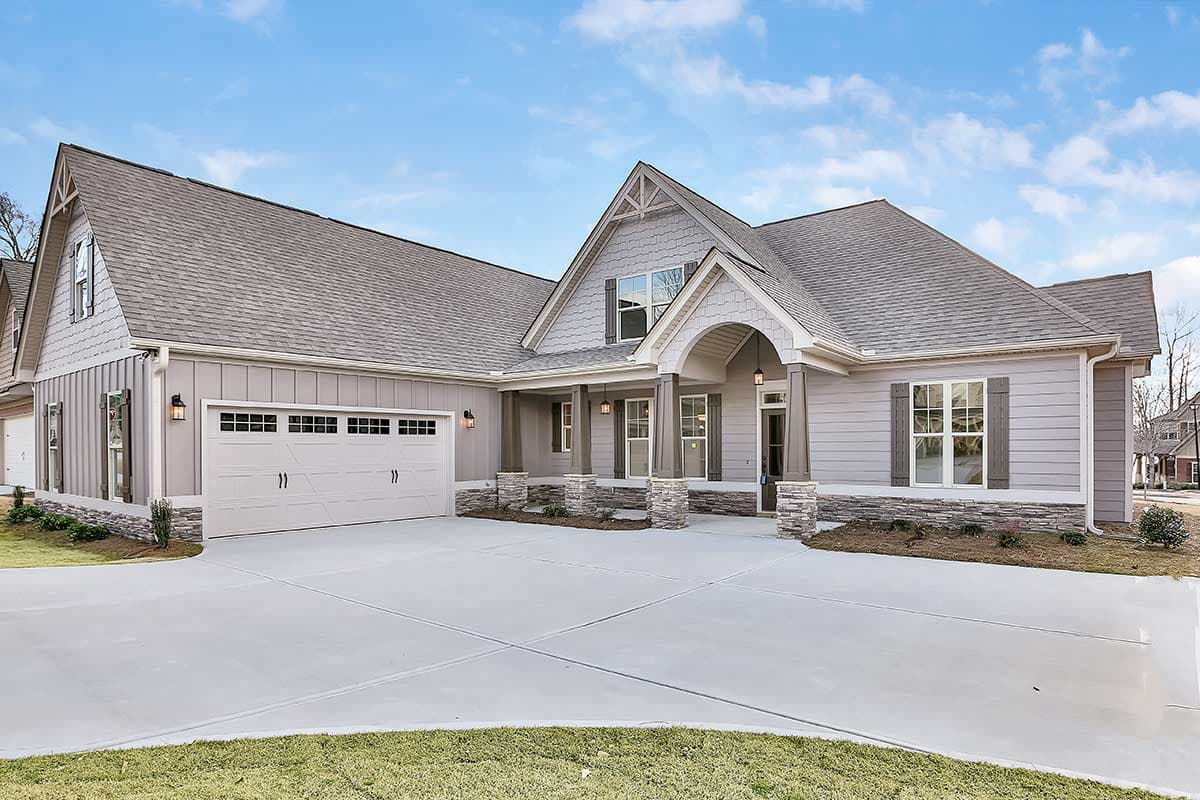 Modern Farmhouse house plan exterior with a two-car garage, arched entry, and stone accents on columns.