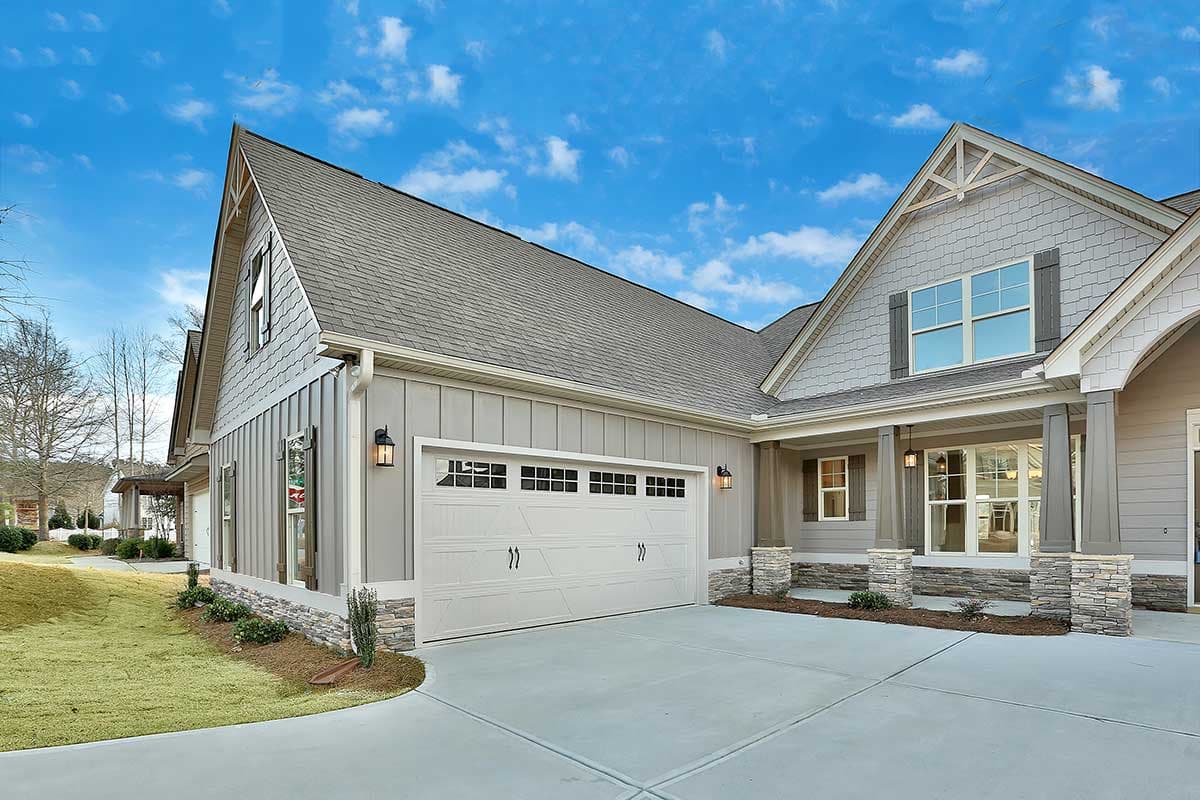 House plan exterior showing a Modern Farmhouse style, two-story home with a prominent gable, board and batten siding, and stone-clad porch supports.