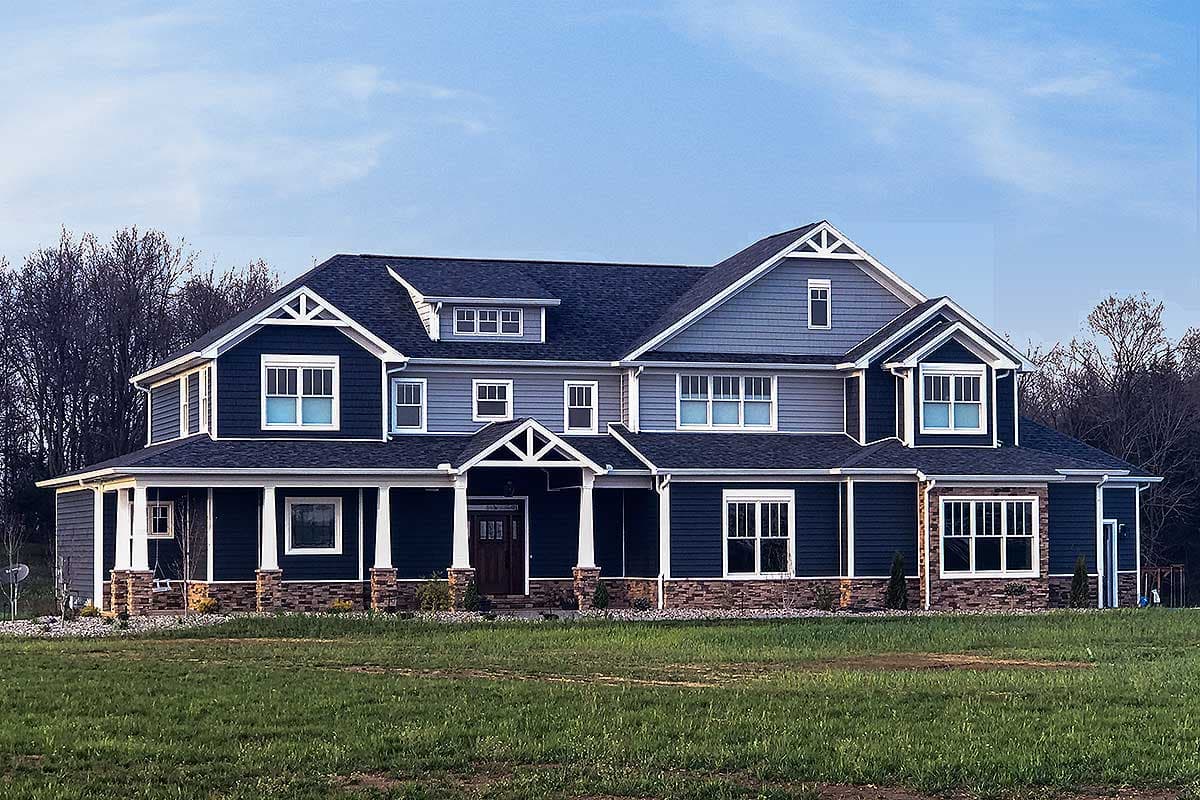 House plan exterior. Two-story home with Craftsman-style elements. Features include a front porch, gables, and a prominent roofline.