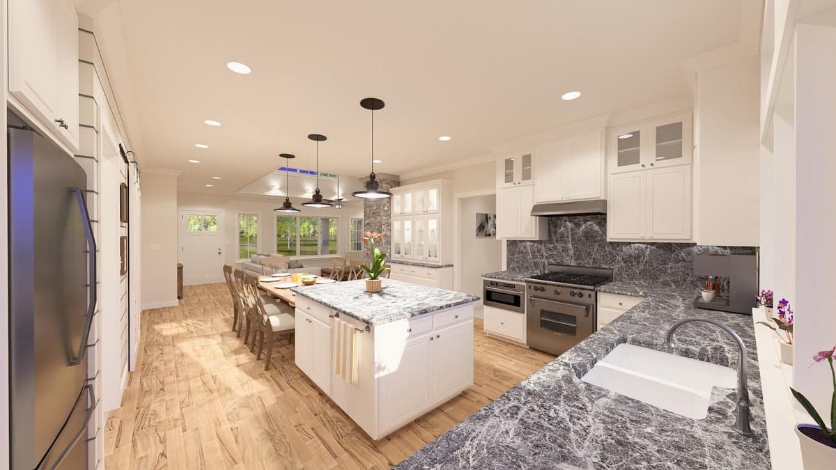 Kitchen with central island, stainless steel appliances, granite countertops, and open view to dining and living areas.