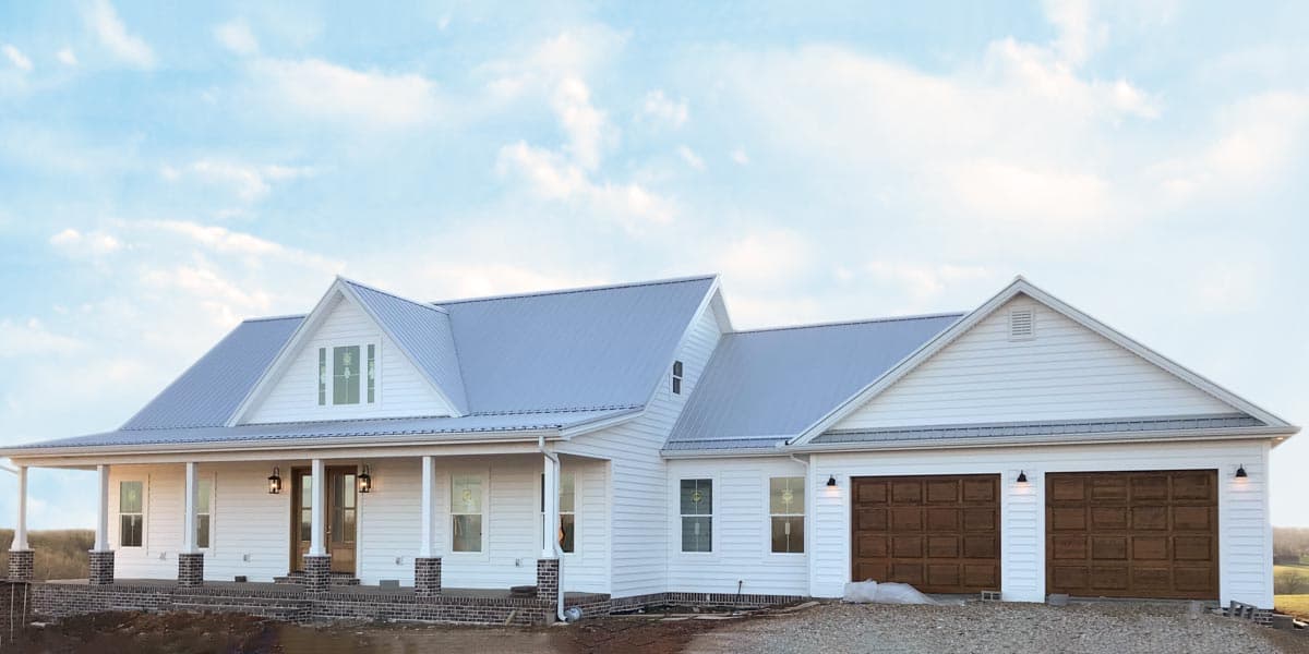 House plan exterior. Two-story Modern Farmhouse with a front porch, multiple gables, and a two-car garage. Features a metal roof and white siding.