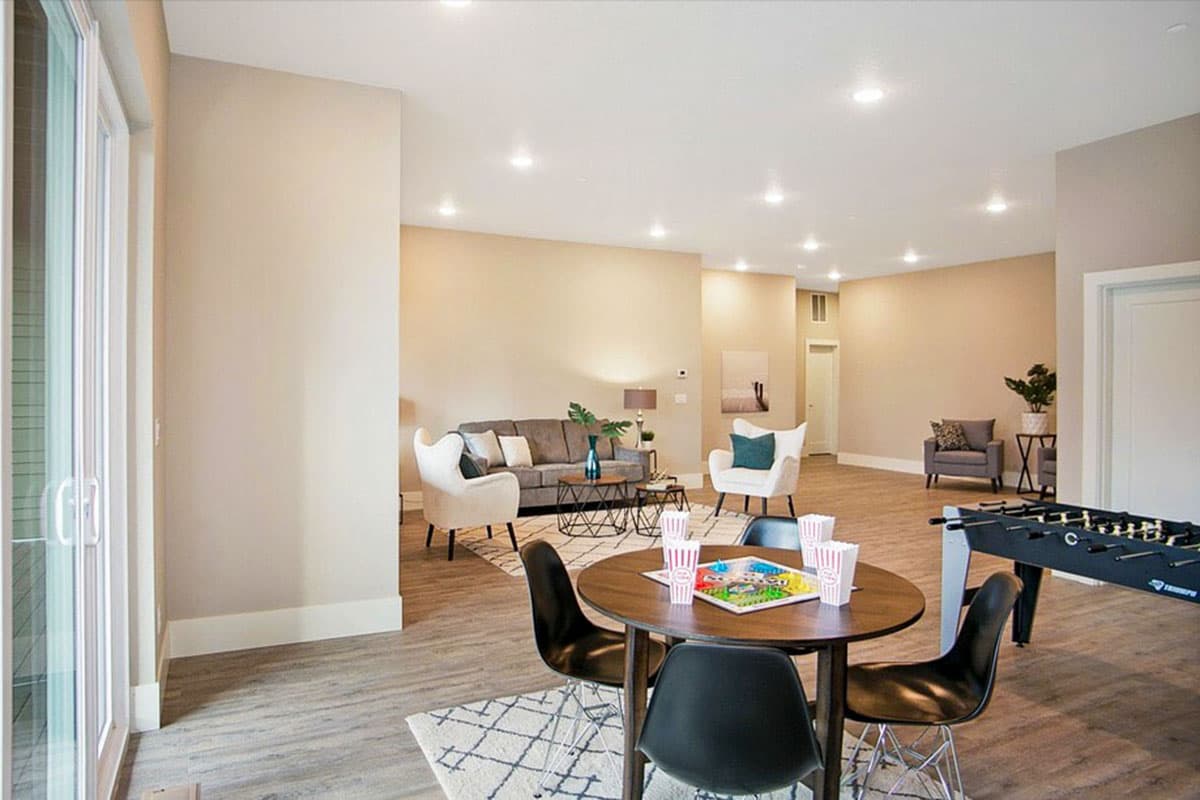 Multipurpose room with seating area, game table, and foosball table.