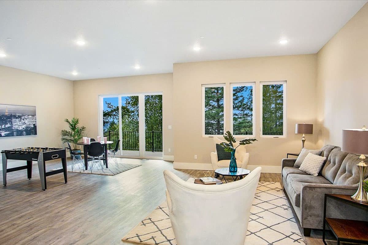Open-concept living and dining area with foosball table, modern furniture, and sliding glass doors to a balcony.