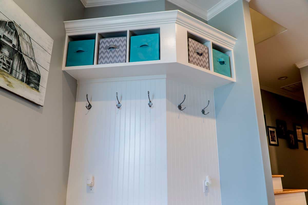 Entryway built-in with cubbies, coat hooks, and beadboard paneling.