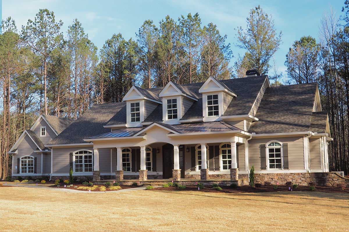 House plan exterior: Two-story Modern Farmhouse with covered porch, multiple gables, dormer windows, and stone foundation.