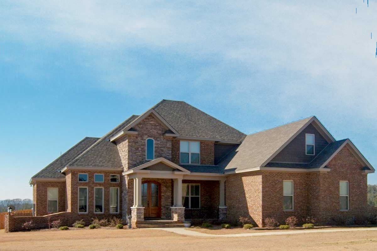 House plan exterior. Two-story brick home with gabled rooflines, a covered porch, and arched window accents.
