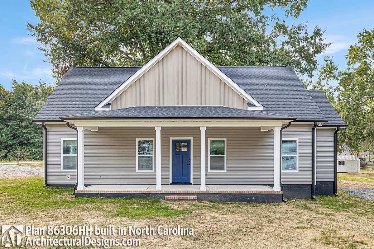 House plan exterior: One-story home with a covered front porch, gabled dormer, and vinyl siding.