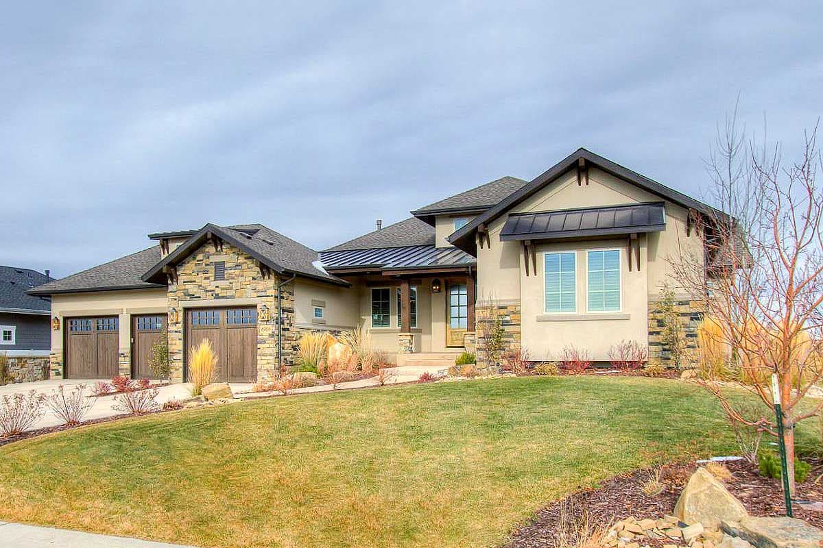 House plan exterior with stone accents, triple garage, covered entry, and dark metal roof accents. Modern style.