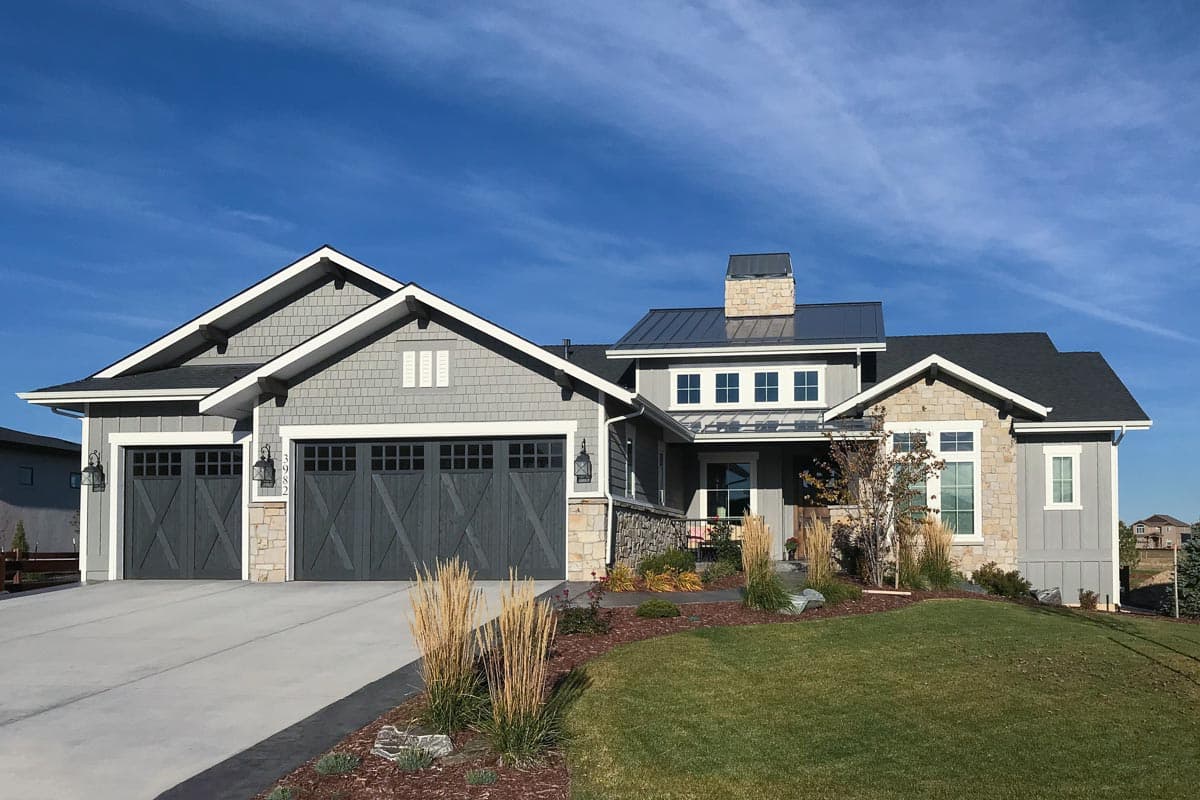 House plan exterior: Craftsman style home with three-car garage, stone accents, and multiple gables.