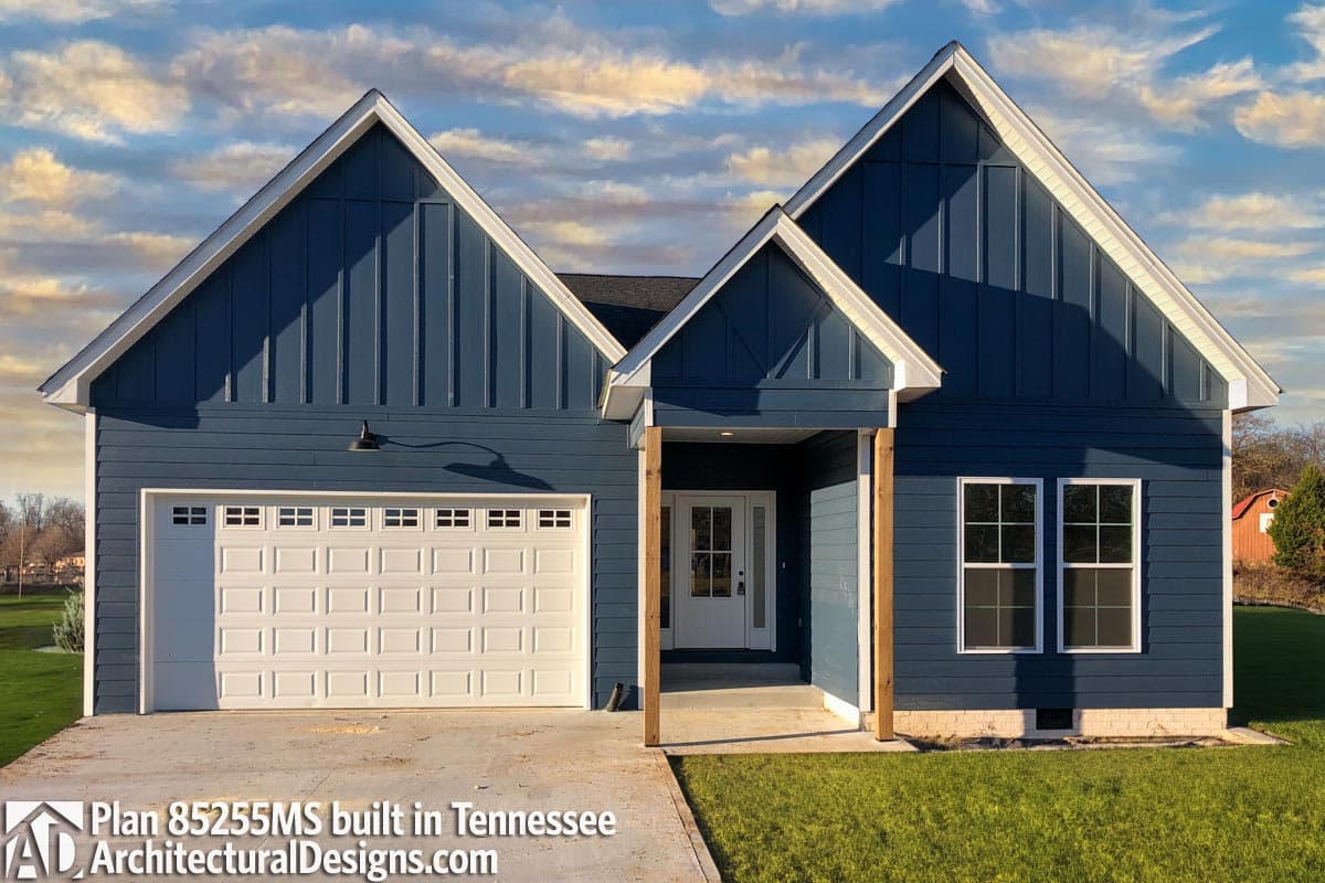 House plan exterior: Modern Farmhouse style, one story, with a gable roof, board and batten siding, and a white garage door.