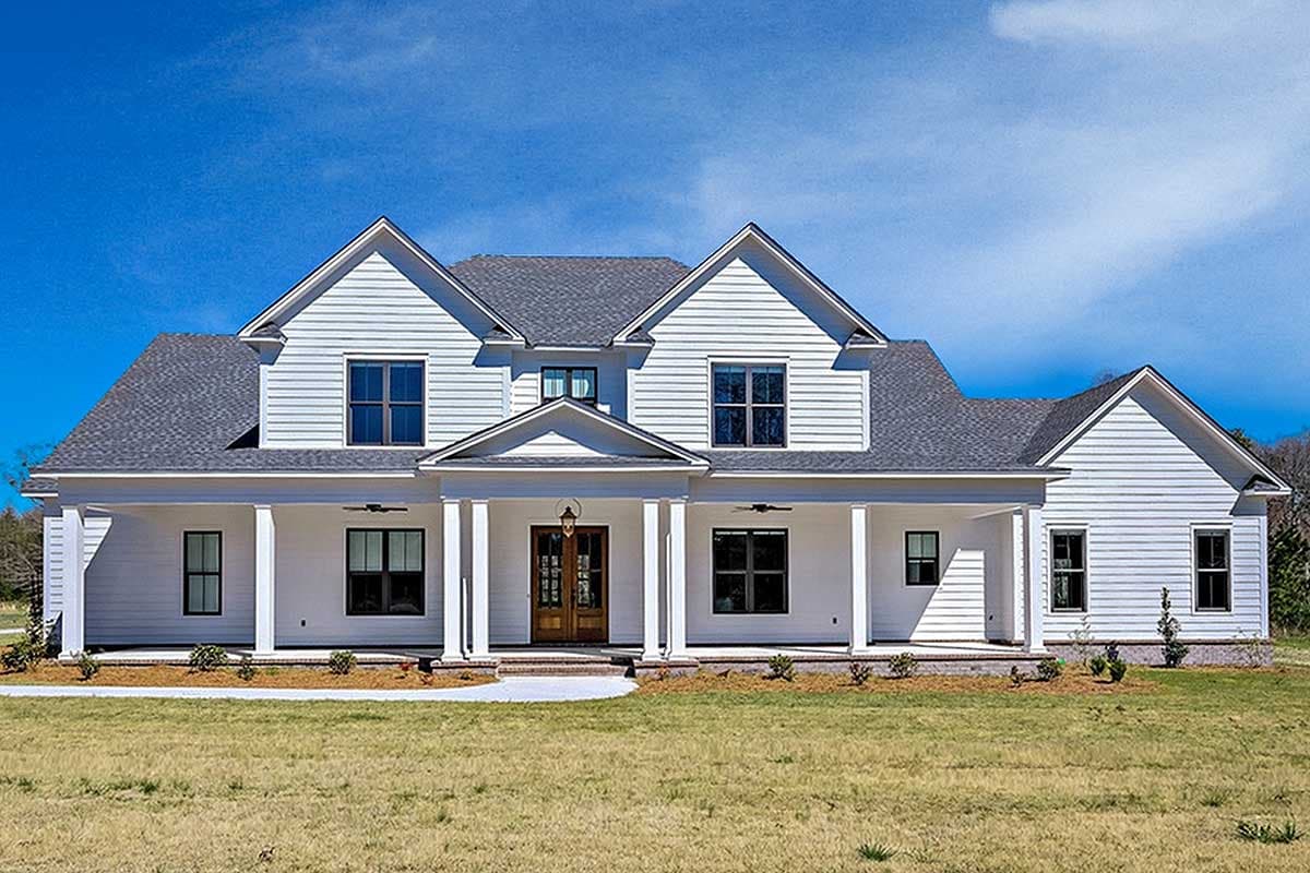 House plan exterior. Two-story home with a wrap-around porch, multiple gables, and symmetrical window placement.