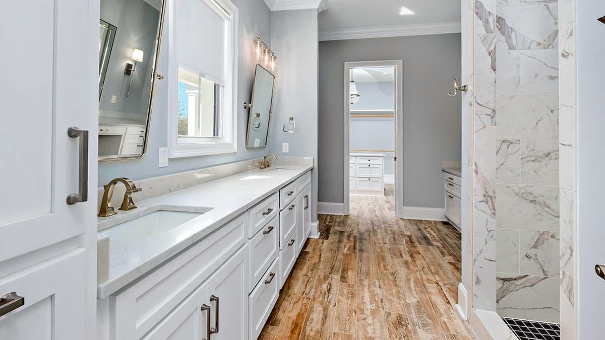 Bathroom with double vanity, marble shower, and walk-in closet.