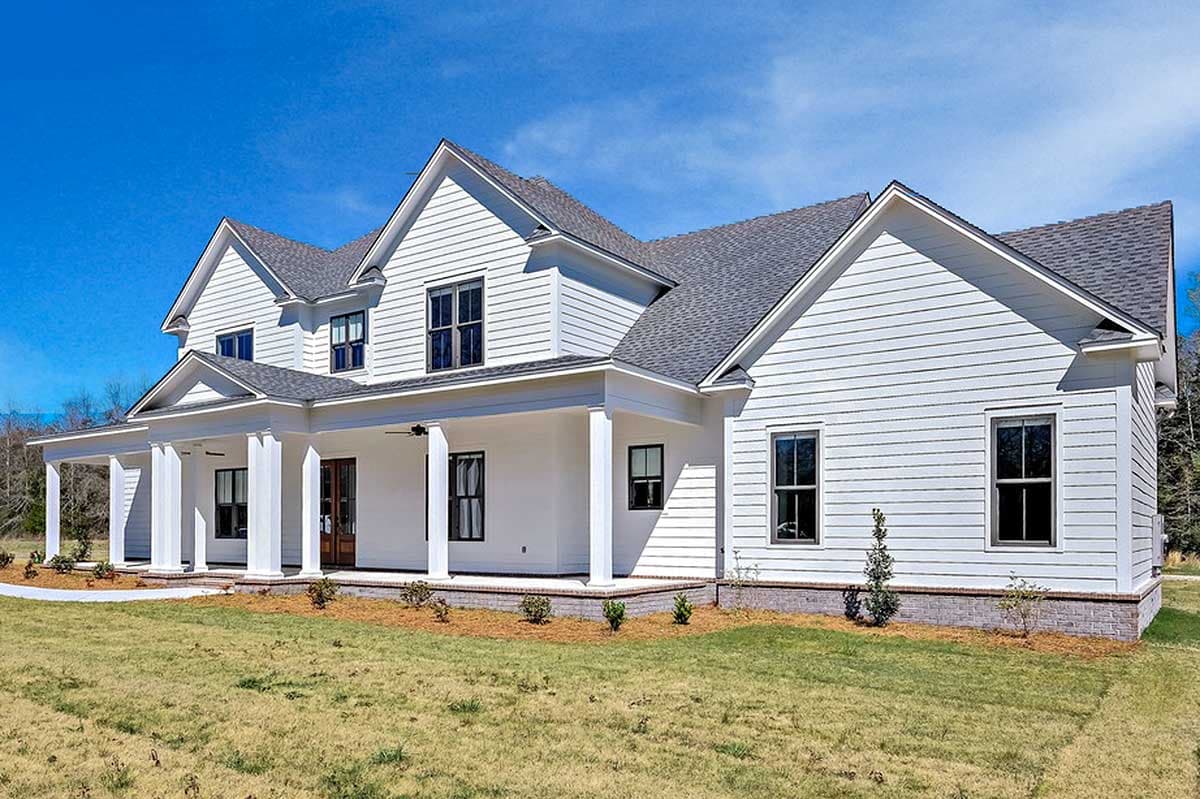 Two-story Modern Farmhouse exterior with a wraparound porch, gables, and horizontal siding.