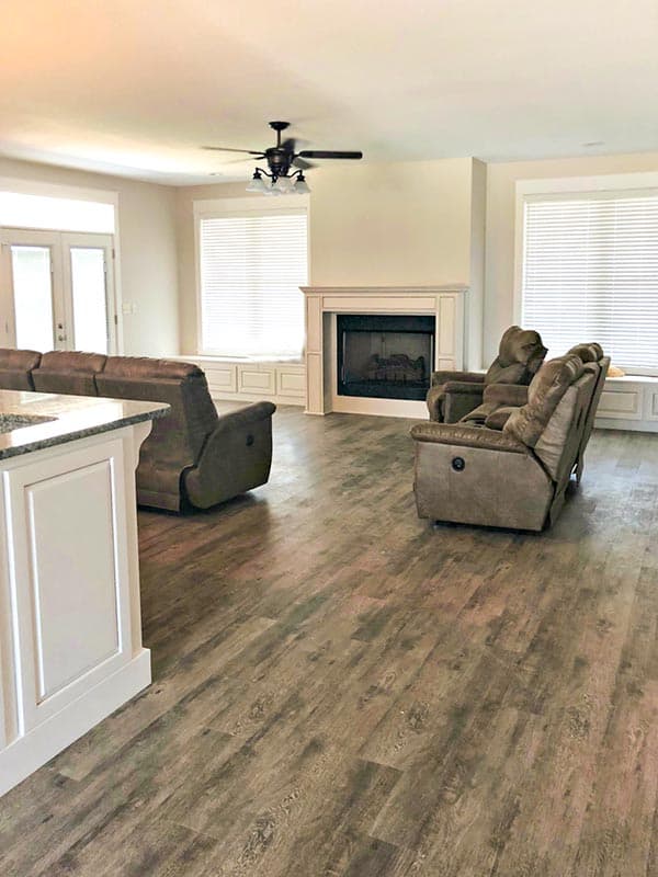 Living room interior with fireplace, seating, and large windows.