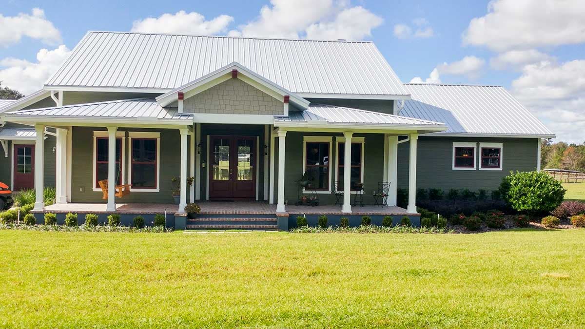 House plan exterior: Modern Farmhouse style, one-story with wrap-around porch, metal roof, and gable dormers.