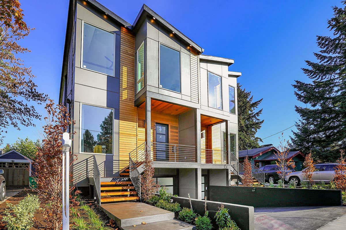 Modern house plan exterior with multiple stories, large windows, wood siding, and covered balconies.