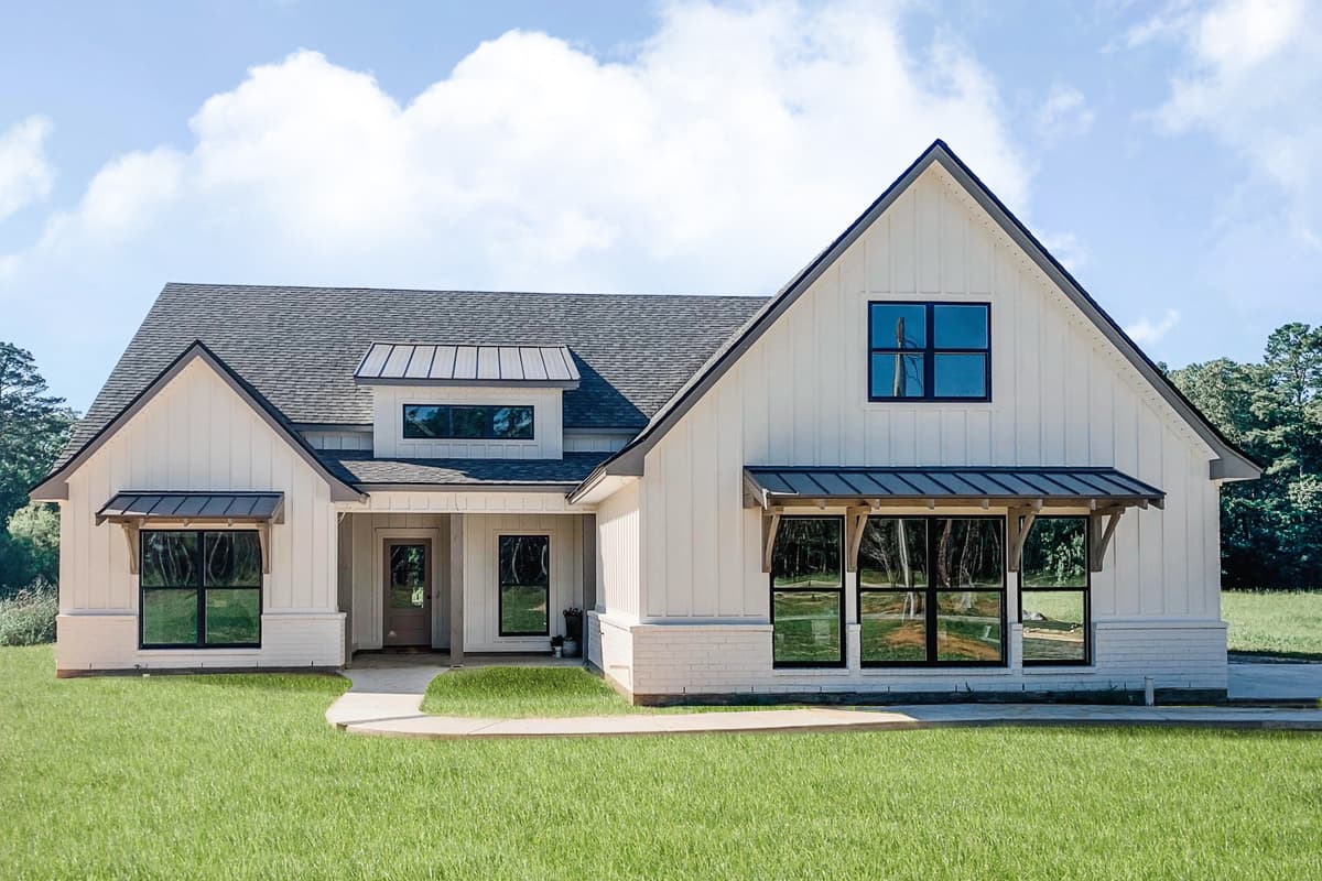 Modern Farmhouse style house plan exterior with board and batten siding, metal awnings, dormer, and large windows.