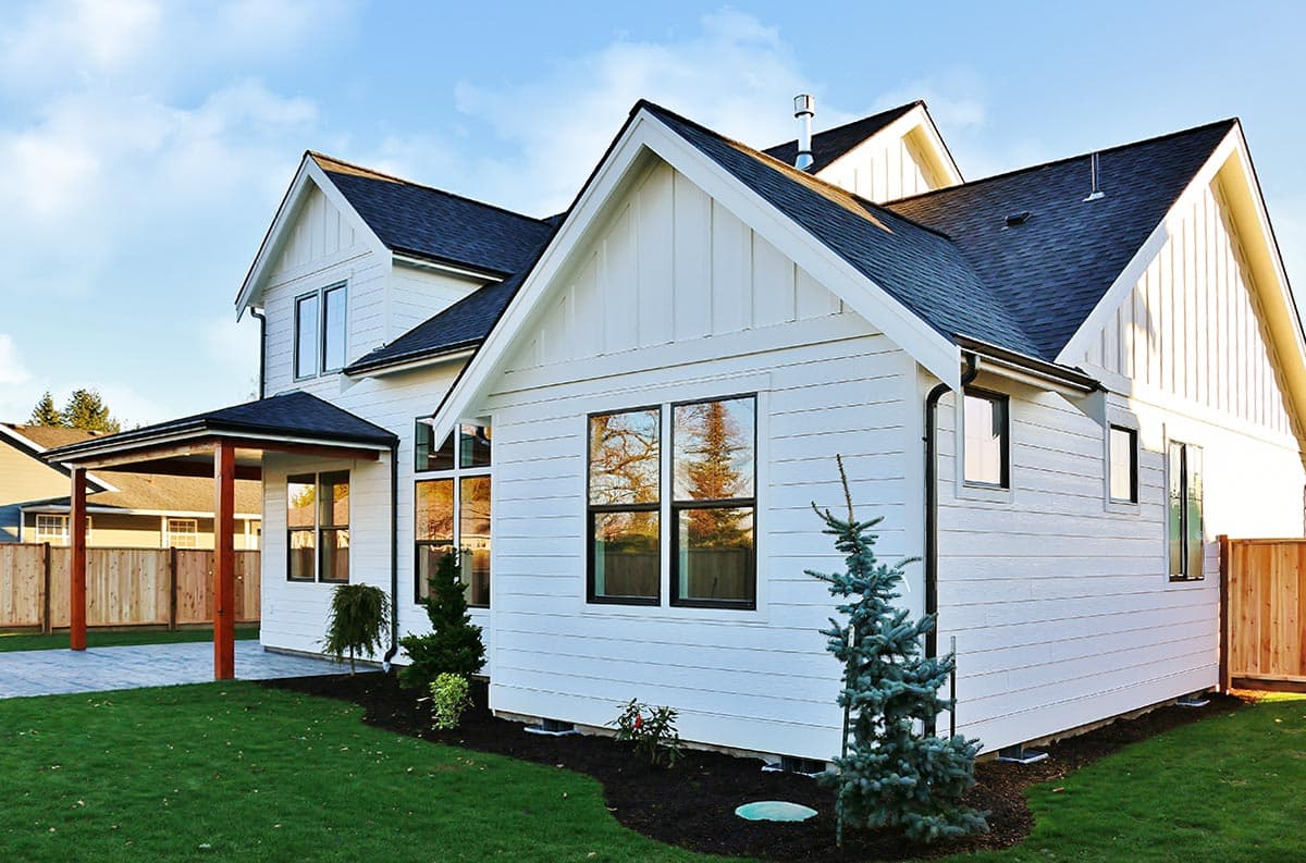Modern Farmhouse house plan exterior with white board and batten siding, gables, and covered porch.