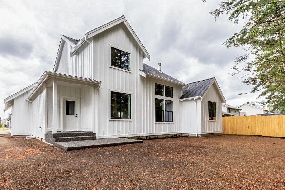 Modern Farmhouse house plan exterior with vertical siding, prominent gables, and a covered entry with black-framed windows.