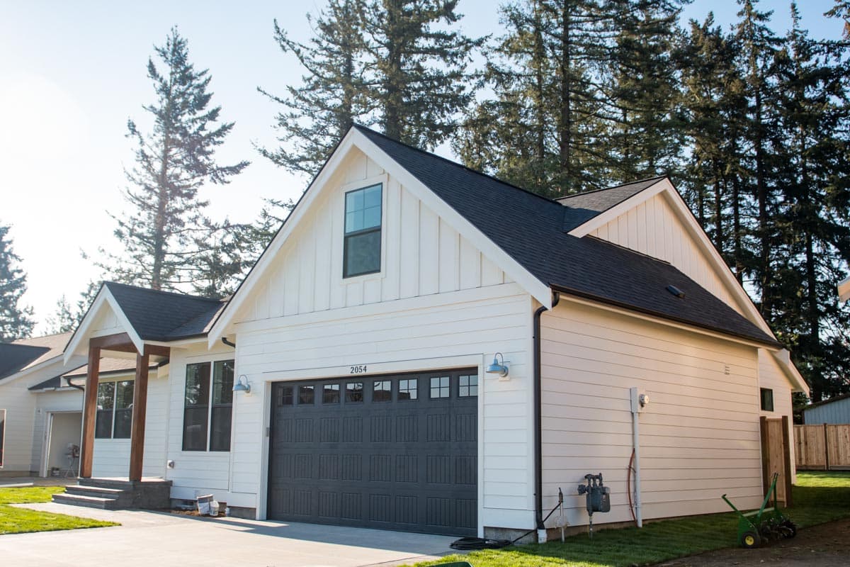 Modern Farmhouse style house plan exterior with a prominent gable, board and batten siding, and a two-car garage.