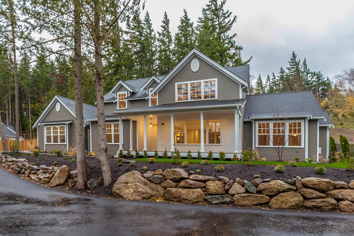 House plan exterior of a two-story Modern Farmhouse with a wrap-around porch, multiple gables, and dormer windows.