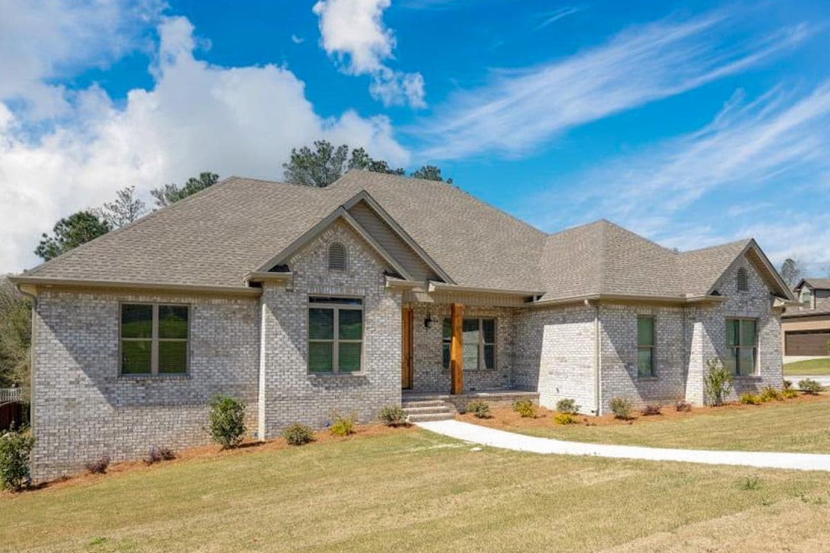 House plan exterior: One-story Modern Farmhouse with brick facade, covered porch supported by wood columns, and multiple gables.